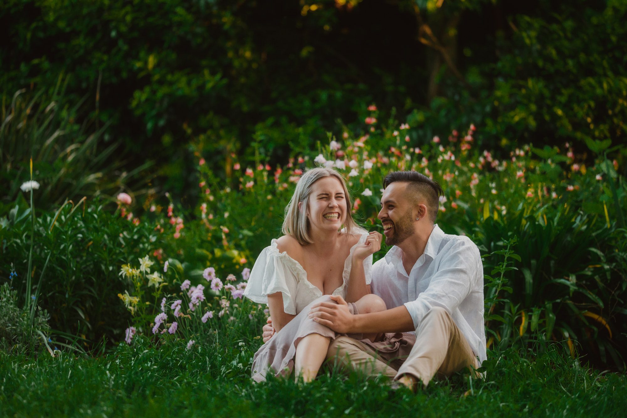 Couple in love happy and laughing sitting on the ground